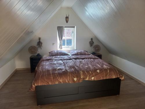 sypialnia z dużym łóżkiem na poddaszu w obiekcie Mariahoeve w mieście Rilland