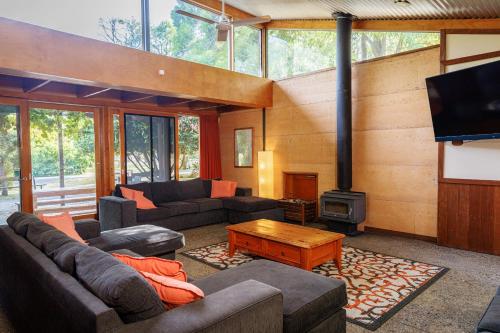 a living room with a couch and a stove at YHA Grampians Eco, Halls Gap in Halls Gap