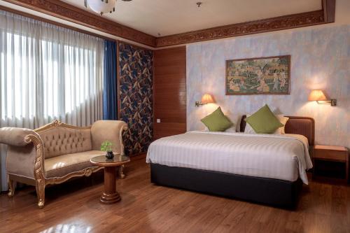 a bedroom with a bed and a couch and a chair at The Hills Batam in Nagoya