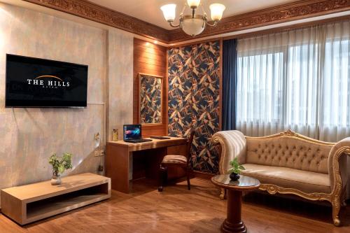 a living room with a couch and a tv on a wall at The Hills Batam in Nagoya