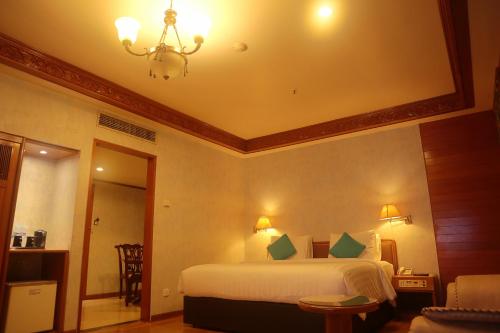 a bedroom with a bed and a chandelier at The Hills Batam in Nagoya