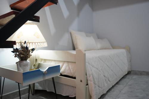 1 dormitorio con 1 cama y 1 mesa con lámpara en La Casa de Sol en Posadas