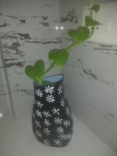 a black and white vase with a plant in it at CLIFF HEAVEN in Varkala