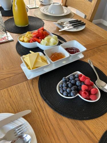 a table with plates of food and bowls of fruit at Bricket House in Great Malvern