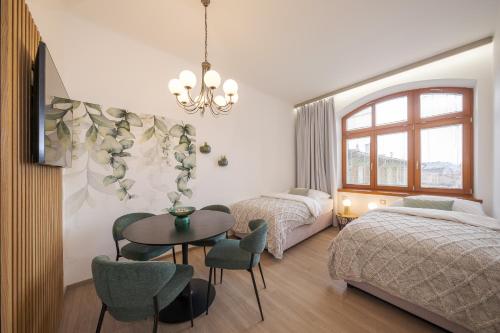 a bedroom with two beds and a table and chairs at Penzion Martina**** in Lanškroun