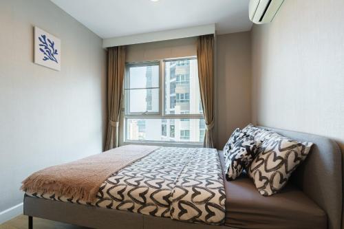 a bedroom with a bed and a window at 182-网红火车夜市边 泳池公寓免费WiFi mrt 100m in Ban Tha Satu