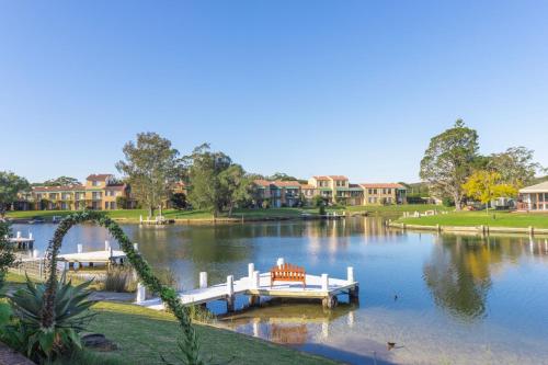 a view of a lake with a dock and houses at Fishermans Delight Waterfront in Sussex inlet
