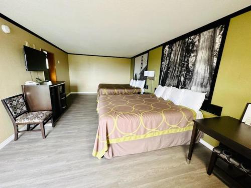 ein Hotelzimmer mit einem Bett und einem Schreibtisch in der Unterkunft Super 8 by Wyndham Crescent City in Crescent City