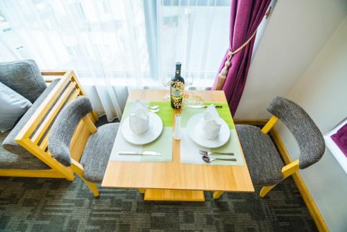 a table with two chairs and a bottle of wine at HANA Stay in Hanoi