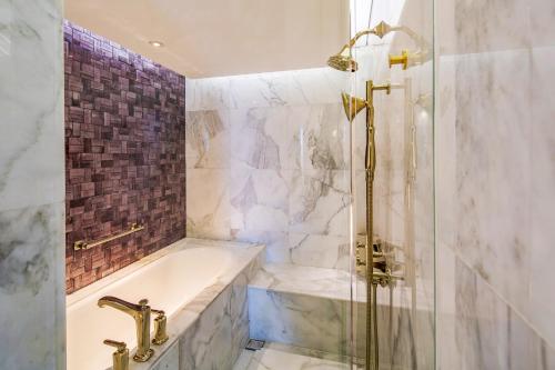 a bathroom with a shower and a tub and a shower at Hotel Indigo Bangkok Wireless Road by IHG in Bangkok