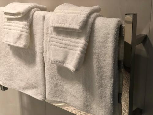 a group of white towels on a rack in a bathroom at Seaview Cottage in Oamaru