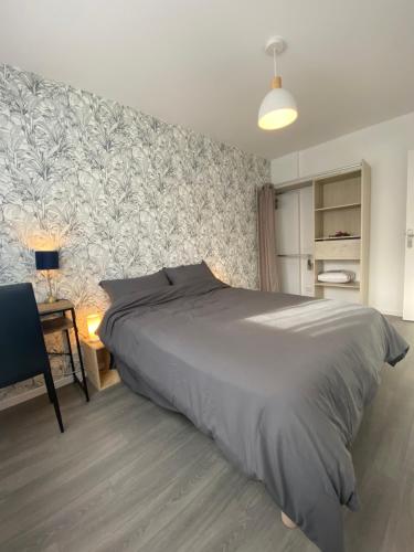 une chambre avec un grand lit et un bureau dans l'établissement Sleep In La Mulatière, à La Mulatière