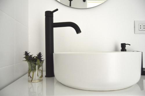 a white bathroom with a sink and a mirror at Nature Rooms-Cozy Cabin in the Woods 