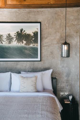 a bedroom with a bed with a picture on the wall at Beach 600M - Designer Villas - Perenenean - Private Pool in Canggu