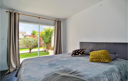 ein Schlafzimmer mit einem Bett und einem großen Fenster in der Unterkunft Nice Home In Carpentras With Wifi, Private Swimming Pool And 3 Bedrooms in Carpentras