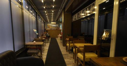 un restaurante con mesas, sillas y luces en Florya House Hotel en Estambul