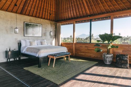 um quarto com uma cama e uma grande janela em DABA - Designer Villas in Perenenan - Beach 600M em Canggu