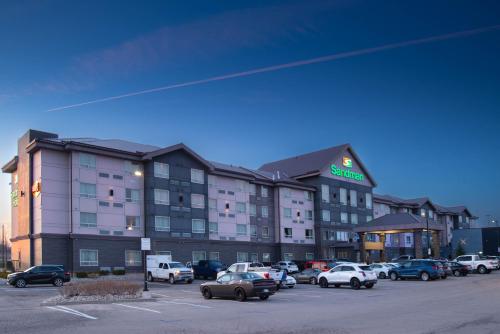 a hotel with cars parked in a parking lot at Sandman Hotel Oakville in Oakville