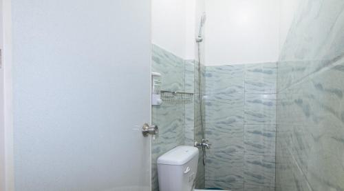 a bathroom with a toilet and a glass shower at Nearest Hostel Pasay City by RedDoorz in Manila