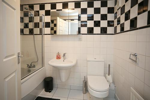 bagno con servizi igienici, lavandino e specchio di Holywood Sea Renity a Holywood