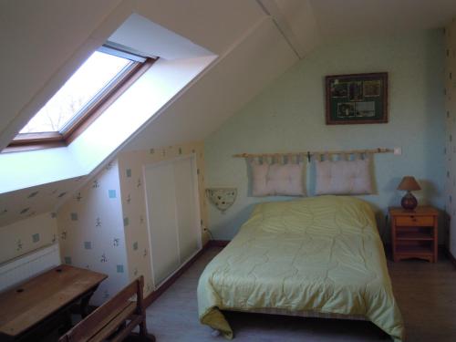 a bedroom with a bed in a attic at Gîte de La Petite Ferme in Criquetot-le-Mauconduit