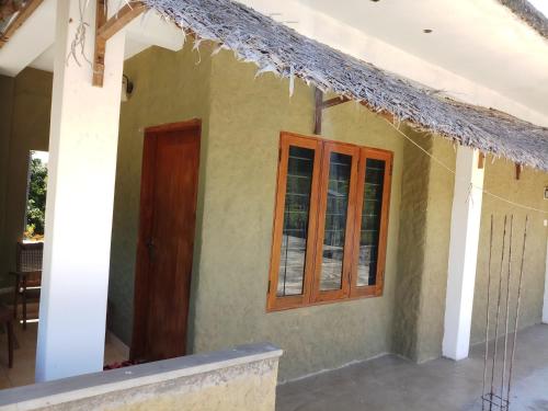 una piccola casa con una porta e una finestra di Inn On The Bay Home a Kalkudah