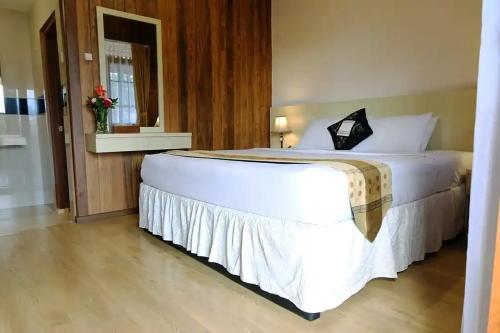 a bedroom with a large white bed in a room at Hotel Pesona Ciwidey in Ciwidey