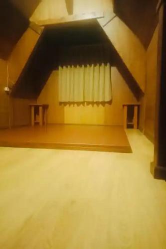 an empty room with two tables and a window at Hotel Pesona Ciwidey in Ciwidey