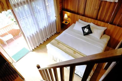 a bedroom with a bed and a balcony at Hotel Pesona Ciwidey in Ciwidey