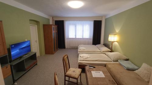 ein Wohnzimmer mit einem Sofa und einem TV in der Unterkunft Apartmán Horní Slavkov Hodinářství in Horní Slavkov