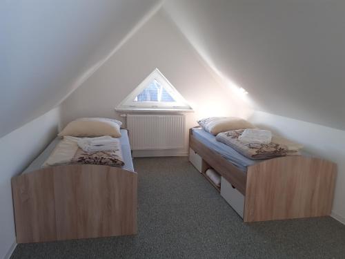 2 camas individuales en una habitación con ventana en Ferienwohnung Richter en Luckau