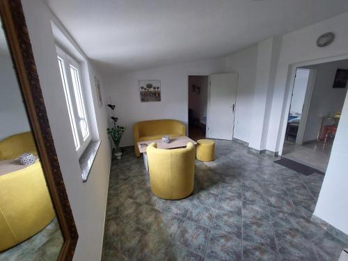 a living room with a table and two yellow stools at Apartment Boras in Senj
