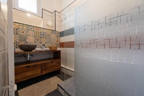uma casa de banho com um lavatório e um espelho em KASA Cocon - Entièrement équipé avec Balcon em Saint-Étienne