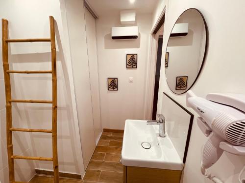 une salle de bain avec un lavabo et un miroir dans l'établissement Chez Mima, à Martigues