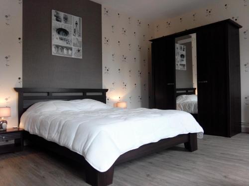 a bedroom with a large white bed and a mirror at Chambres d'hôtes -- Le Clos de Gémozac in Gémozac