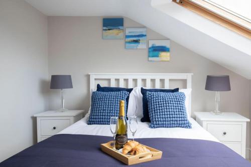 a bed with a bottle of champagne and a tray of bread at Stunning 5 Bed 4 Bath Period Home in Cheltenham