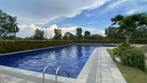 een zwembad met blauw water in een tuin bij Blessimore Springhill 4BR in Palembang