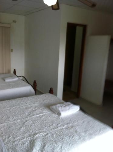 a bedroom with two beds with towels on them at Pedasi Sports Club in Pedasí Town