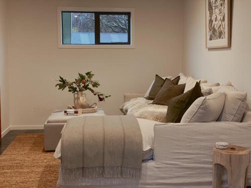 a living room with a white couch and a table at Wanaka Deluxe Studio in Wanaka