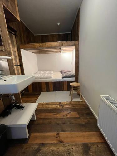 een kleine kamer met een wastafel en een bed bij Residence het Centrum in Oostkapelle