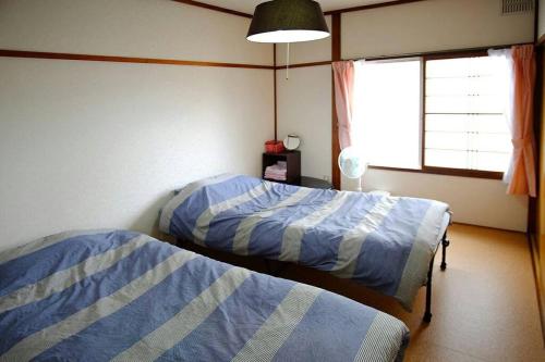 une chambre avec deux lits et une fenêtre dans l'établissement Corpo Marika C, à Hakodate