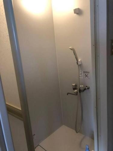 a shower stall in a bathroom with a phone at Corpo Marika C in Hakodate