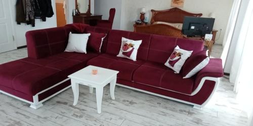 a living room with a red couch and a table at хотел Кристиан in Sozopol