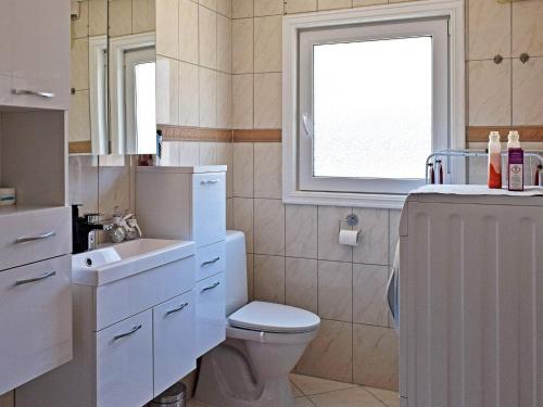 Un baño con inodoro, lavabo y ventana. en 5 person holiday home in Frederikstad-By Traum, en Fredrikstad