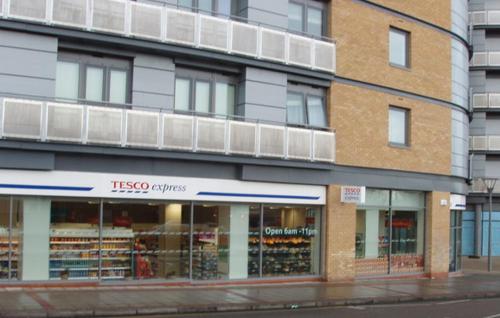 a building with a tikko surveys store on a street at Luxurious Room Near Train Station in London