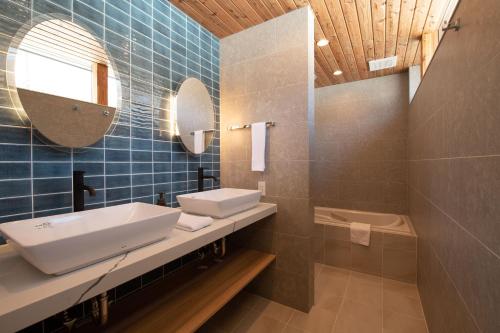 俱知安的住宿－Akiyama，浴室配有盥洗盆、镜子和浴缸