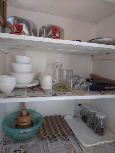 a shelf with dishes and other items in a refrigerator at Almah Apartments in Kisumu