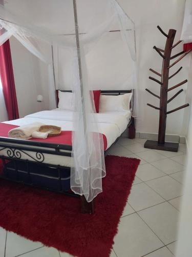 a bedroom with a bed with a mosquito net at Almah Apartments in Kisumu