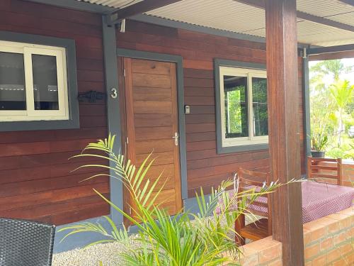ein Haus mit einer Holztür und einer Veranda in der Unterkunft Lilicam Studio in Saint-Georges
