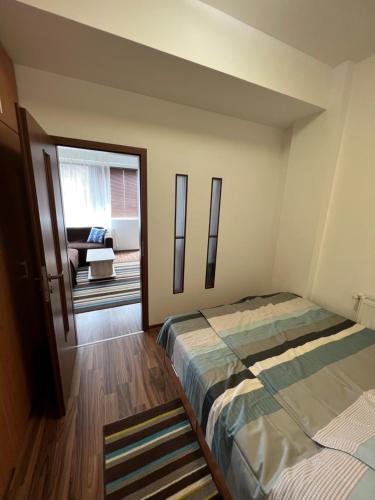 a bedroom with two beds and a living room at Apartament modern Ared UTA in Arad